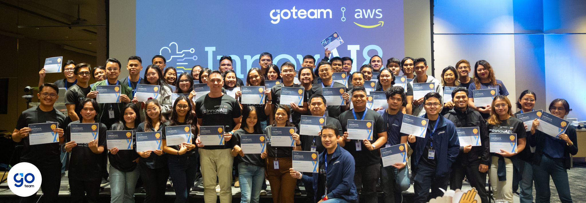 GoTeam and AWS participants holding certificates on stage at the InnovAI8 Summit